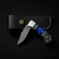 Folding knife with blue handle and black sheath on a dark background